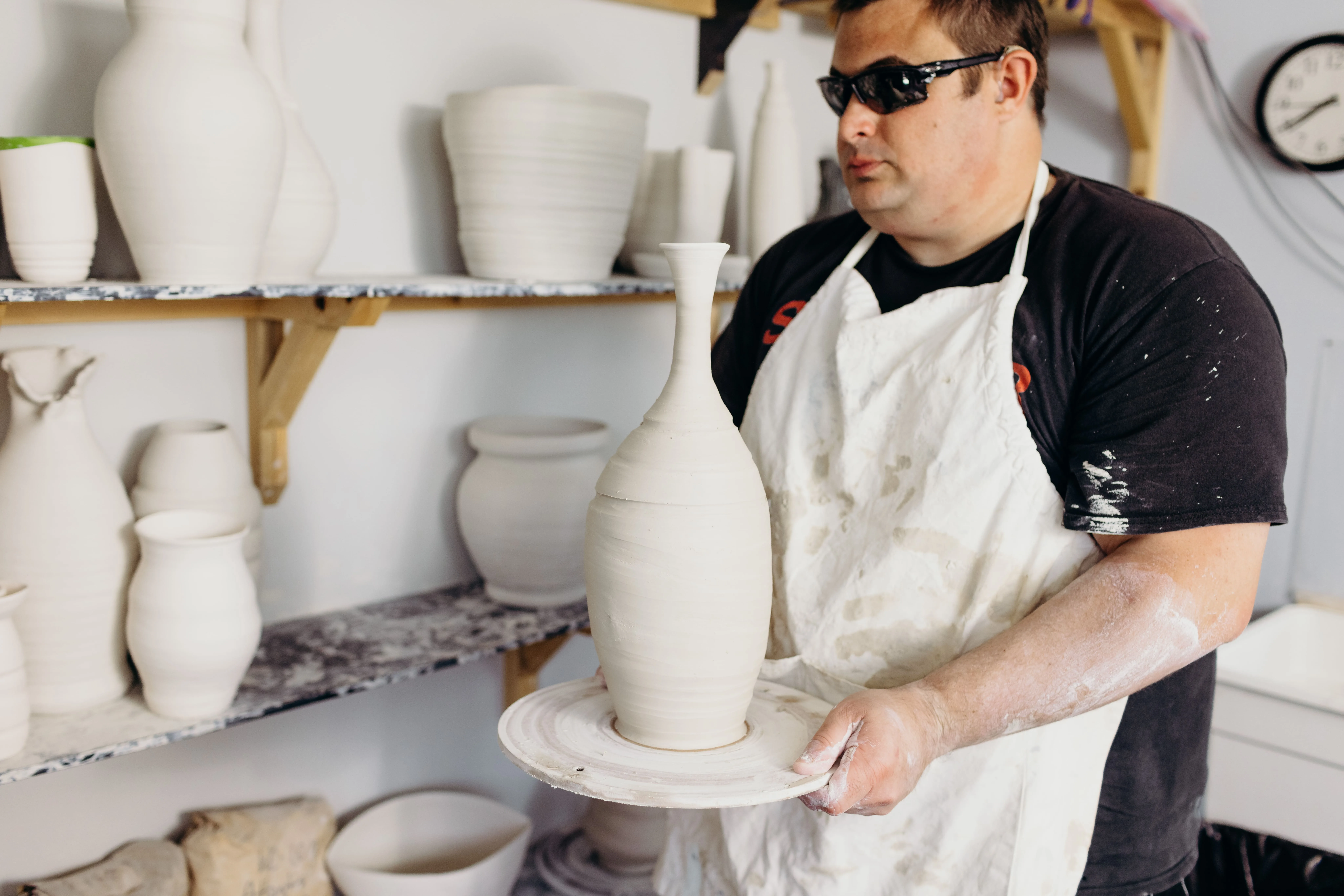 Kelvin holding a vase in the pottery studio Kelvin holding a vase in the pottery studio